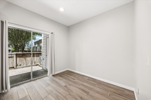 The dining area is washed in natural light open to private patio overlooking greenspace.