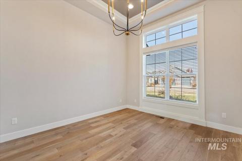 Formal dining room featuring a chandelier, light wood-type flooring, and a high ceiling