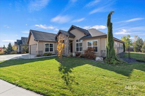 View of front facade featuring stone siding, stucco siding, driveway, and an attached garage
