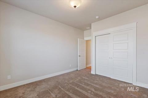 Unfurnished bedroom featuring carpet and a closet