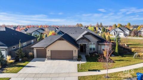 View of front of property with stone siding, stucco siding, an attached garage, and a residential view