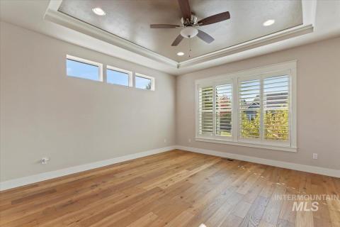 Master Bedroom featuring a tray ceiling, light wood-style floors, ceiling fan, and recessed lighting