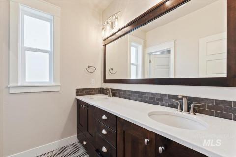 Bathroom with double vanity and tasteful backsplash