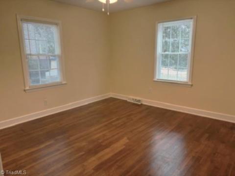 BEDROOM 1 WITH BEAUTIFUL HARDWOOD FLOORS, FRESH PAINT AND VINYL WINDOWS.