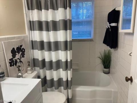 COZY BATH... CAST IRON TUB/ SHOWER WITH TILE SURROUND.  NEW VANITY, LIGHT, TOILET.