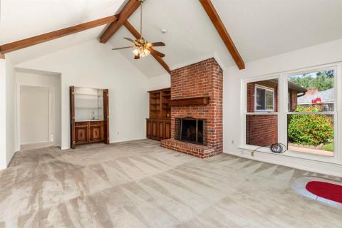 Family Room with wood burning fireplace, built in bookshelves, wet bar, beamed ceiling and tons of natural light.