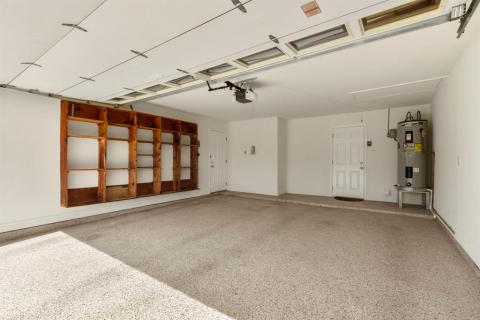 Garage with finished walls and coated floor.  Built in shelving, auto garage door and even an outside land line!