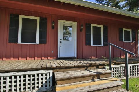 Featuring a welcoming wooden porch and steps, this house is complemented by black shutters and lantern-style lighting. Perfect for relaxed living. Featuring a welcoming wooden porch and steps, this house is complemented by black shutters and lantern-style lighting. Perfect for relaxed living.