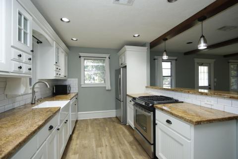This photo showcases a modern kitchen with white cabinetry, granite countertops, and stainless steel appliances. The space features a farmhouse sink, subway tile backsplash, and pendant lighting, creating a bright and inviting atmosphere. This photo showcases a modern kitchen with white cabinetry, granite countertops, and stainless steel appliances. The space features a farmhouse sink, subway tile backsplash, and pendant lighting, creating a bright and inviting atmosphere.