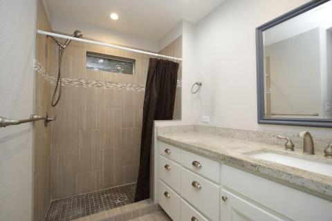 This bathroom features a spacious walk-in shower with elegant tile work and a modern vanity with a beautiful countertop, ample storage, and a large mirror. The soft lighting complements the neutral color palette for a clean, inviting space. This bathroom features a spacious walk-in shower with elegant tile work and a modern vanity with a beautiful countertop, ample storage, and a large mirror. The soft lighting complements the neutral color palette for a clean, inviting space.