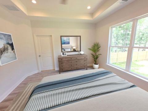 Bedroom featuring a tray ceiling, wood finished f