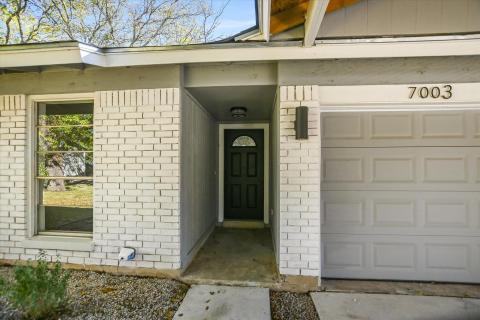 Property entrance with brick siding and a garage