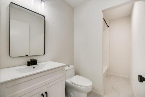 Full bath featuring light marble finish floors, v