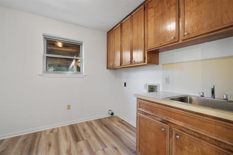 Laundry room with washer hookup, light wood finis