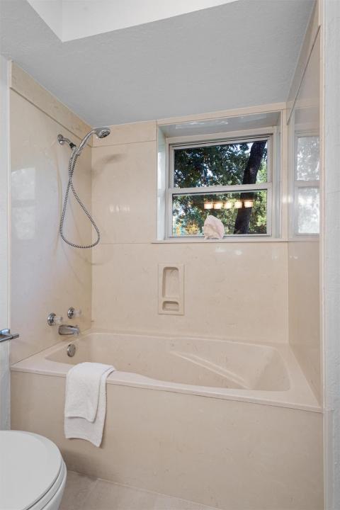 Bathroom with toilet and bathing tub / shower com
