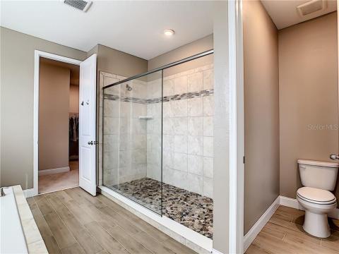 Semi frameless shower with upgraded pebbles shower floor, dry off area and privacy lavatory
