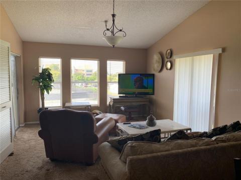 Living room showing slider on left to screen lanai and slider to right to small Juliet balcony. Doors are to cathedral bedroom with its own full bath ensuite.