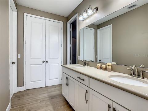 Bathroom #2 with height raised cabinets, double sinks, bathtub and ample linen closet