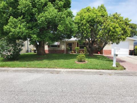 Big trees shade the front of the home and the landscape is well maintained.