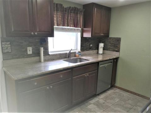 Ktichen with window over sink looking into backyard and granite countertops.