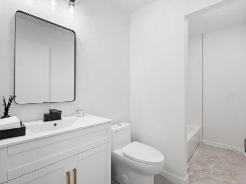 Full bathroom with vanity, toilet, concrete floor