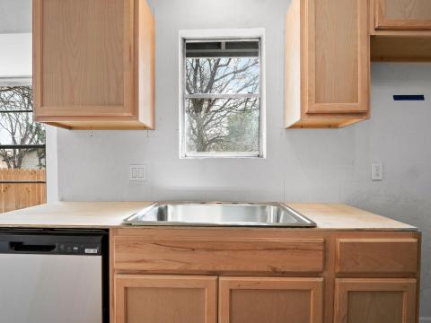 Kitchen featuring dishwasher, light brown cabinet