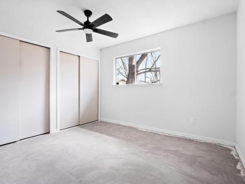 Unfurnished bedroom with a ceiling fan, multiple 