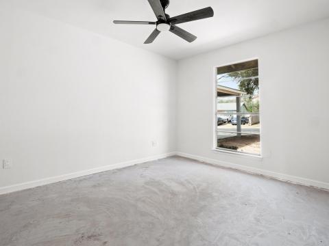 Spare room featuring baseboards, concrete floorin