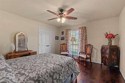 Bedroom with dark wood-style flooring, a closet, 