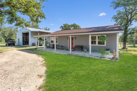 Rear view of house with a lawn, covered porch, an