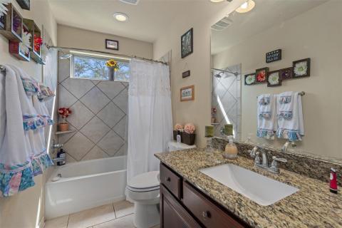 Bathroom with shower / tub combo, vanity, and lig