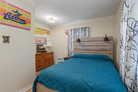 Bedroom with light wood finished floors and a tex
