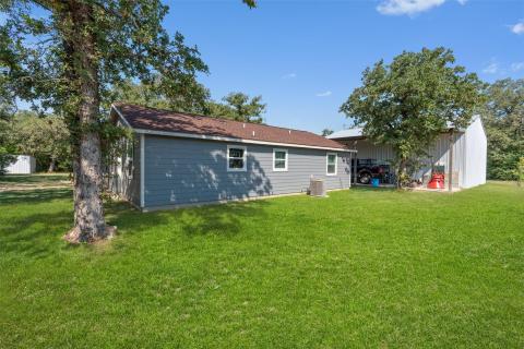 Rear view of property featuring a lawn and an out