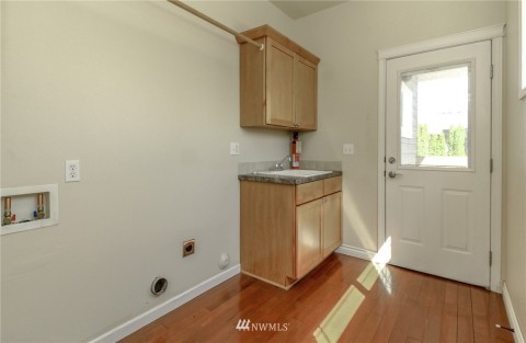 Large utility room with laundry sink and storage. Light & bright here too. Back door shown too.