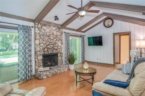 Family room has two sliders leading to screened porch an a wood burning fireplace. Soaring ceilings and hardwood flooring.