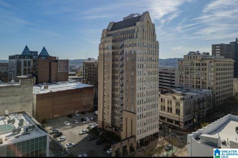 Historic high-rise structure featuring intricate facade detailing, multiple stories of window-lined units, and a distinctive peak roofline