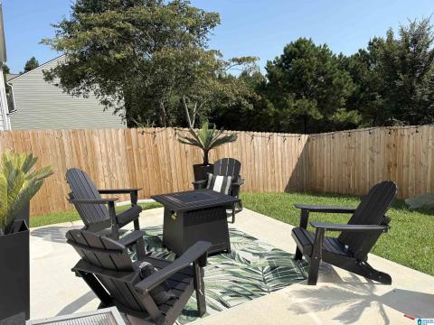 Private backyard with a wood privacy fence, concrete patio, and manicured lawn