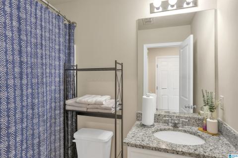 Bathroom vanity featuring a polished chrome faucet, an undermount sink, and a speckled countertop